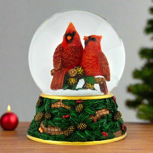 Festive Snow globe with two red cardinals in Holiday Scene